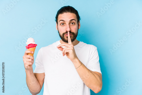 Young caucasian man eating an ice cream isolated keeping a secret or asking for silence.
