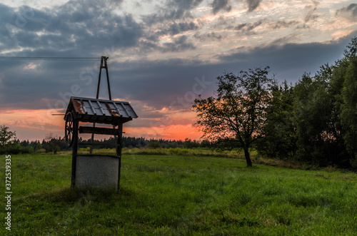 Sunset behind well in the countryside
