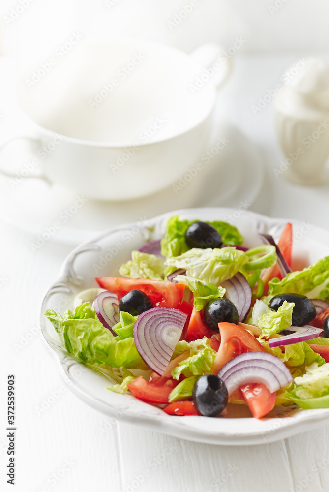 Healthy salad with black olives, tomatoes and red onion on bright wooden background. Healthy salad with black olives, tomatoes and red onion on bright wooden background.