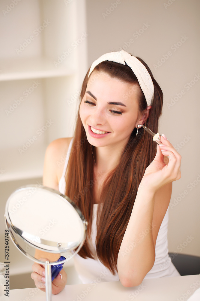 Naklejka premium sitting at home, looking in the mirror, laughing and having fun. Morning skin care regimen.