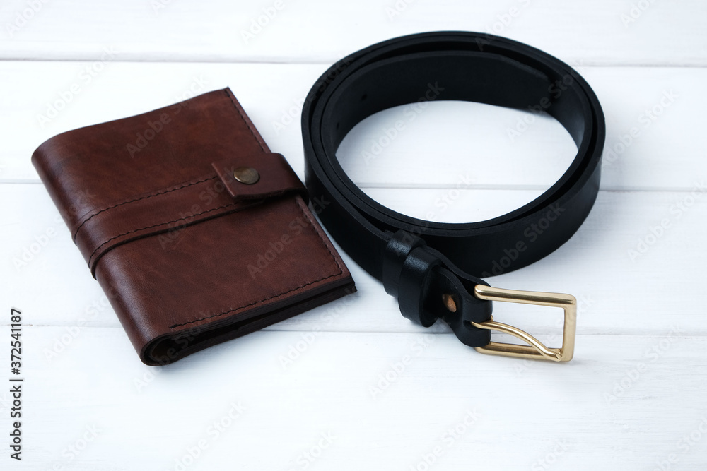 Wallet and belt made of genuine leather on white wooden background with copy space Wallet and belt made of genuine leather on white wooden background with copy space