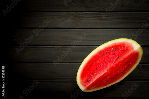 Slice of ripe watermelon on black background, top view