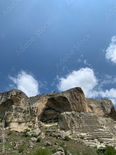 Mountains on the blue sky background. Blue sky with white clouds. 