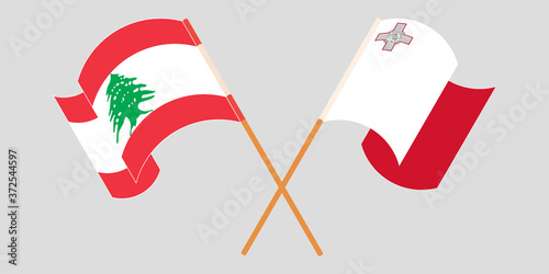 Crossed and waving flags of Lebanon and Malta