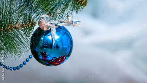 Blue shiny Christmas ball on Christmas tree, copy space