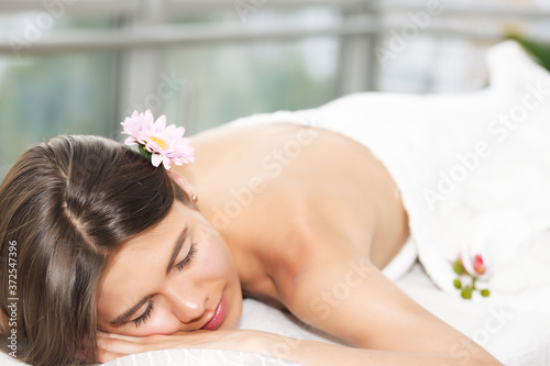 Young woman enjoying massage in spa salon