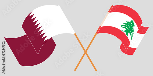 Crossed and waving flags of Lebanon and Qatar
