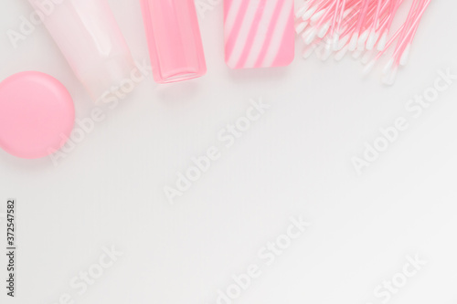 Cosmetics for beauty and skin care, makeup. Foam cleansing, moisturizing, nourishing from acne and wrinkles, tonic, lip balm, cotton buds, natural soap on a pink background with copyspace
