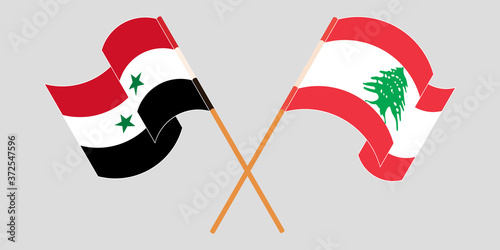Crossed and waving flags of Lebanon and Syria