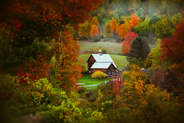 Barn in rural Vermont nestled between fall foliage
