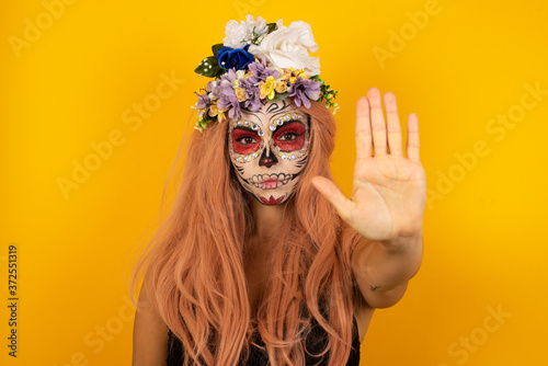 Young beautiful caucasian woman doing stop gesture with palm of the hand. Warning expression with negative and serious gesture on the face isolated over gray background.