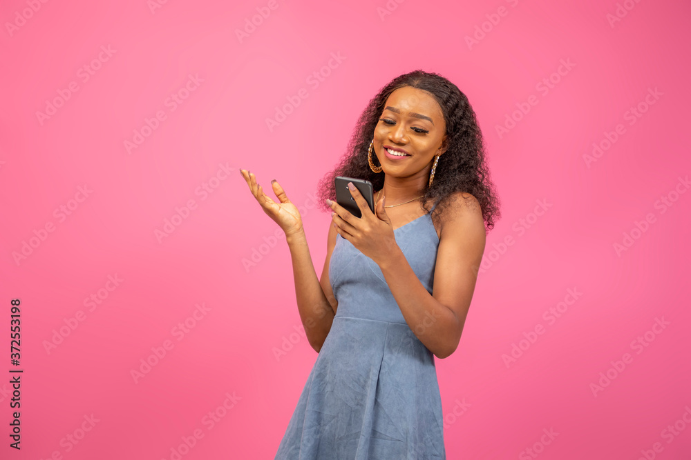 beautiful african lady smiling while using her phone beautiful african lady smiling while using her phone
