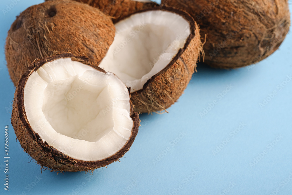 Coconut fruits on blue vibrant plain background, abstract food tropical concept, angle view macro Coconut fruits on blue vibrant plain background, abstract food tropical concept, angle view macro