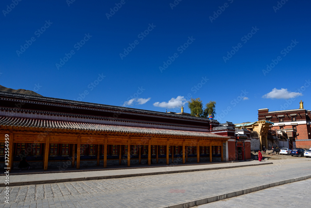 Tibetan prayer wheels at Labrang Monastery in Xiahe County, China. Translation text written in sanskrit means Tibetan prayer wheels at Labrang Monastery in Xiahe County, China. Translation text written in sanskrit means