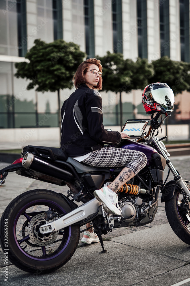 Very beautiful girl on a stylish purple motorcycle