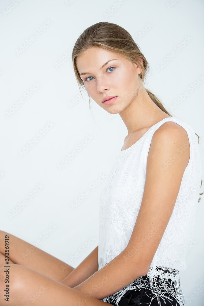 young beautiful woman with tanned skin sits on light floor, young beautiful woman with tanned skin sits on light floor,