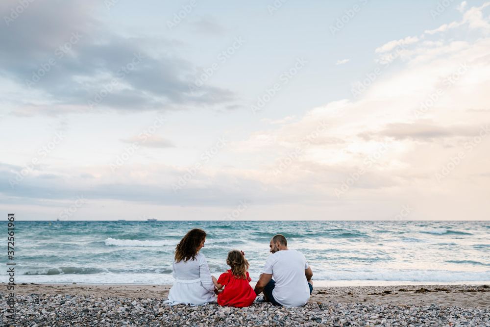 Family spending quality time on shore at beach against cloudy sky Family spending quality time on shore at beach against cloudy sky