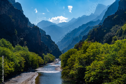 Loving landscape with mountains, forest and a river in front located in Greece. Beautiful scenery ideal for wallpaper taken from Greek mythology.