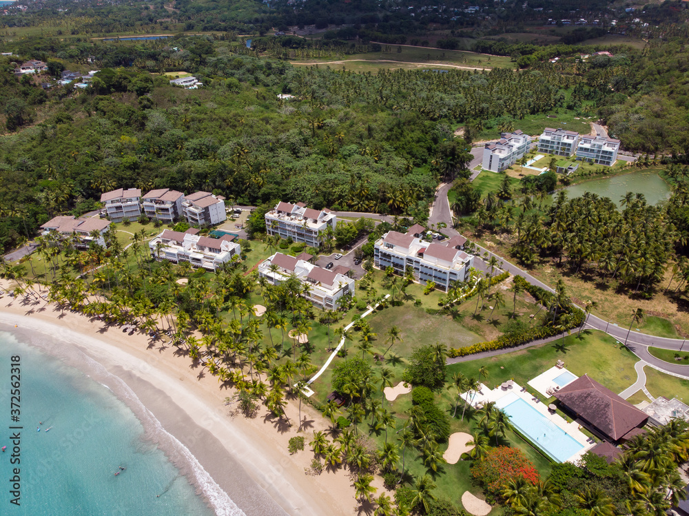 Real estate at the paradise beach with blue water and palm trees in Las Terrenas, Samana, Dominican Republic 