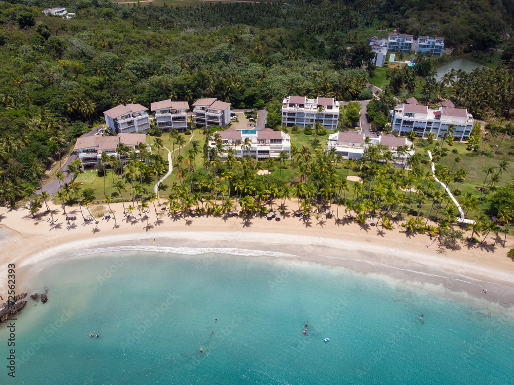 Real estate at the paradise beach with blue water and palm trees in Las Terrenas, Samana, Dominican Republic 