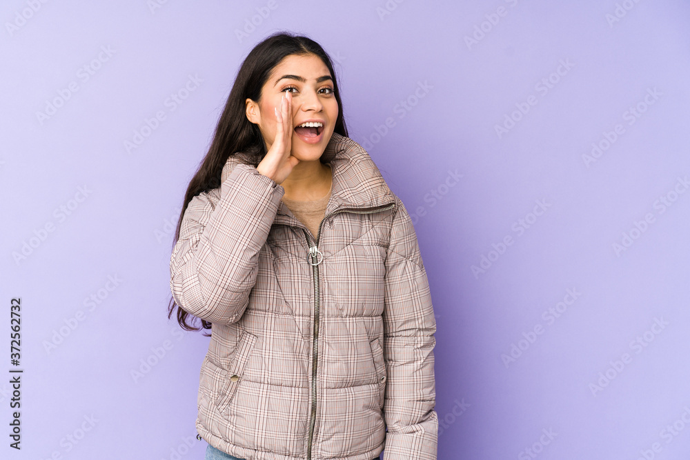 Young indian woman isolated on purple background shouting excited to front. Young indian woman isolated on purple background shouting excited to front.