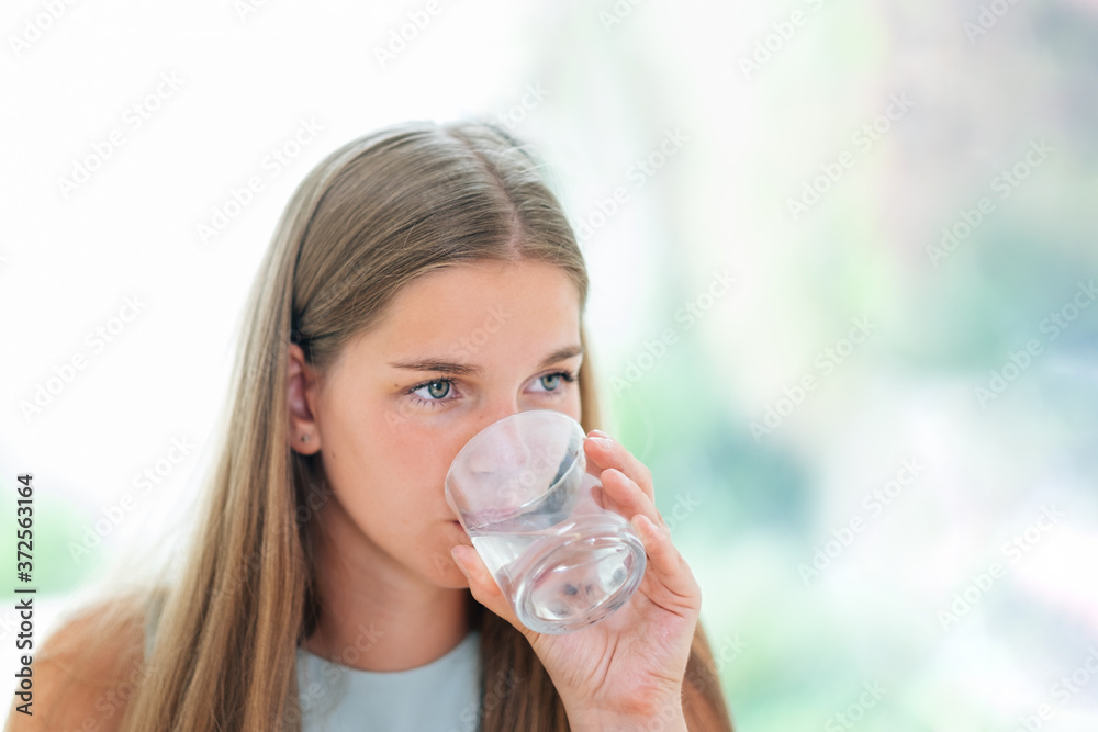 healthy young woman drinking water, closeup portrait of a beautiful girl holding a glass of water healthy young woman drinking water, closeup portrait of a beautiful girl holding a glass of water