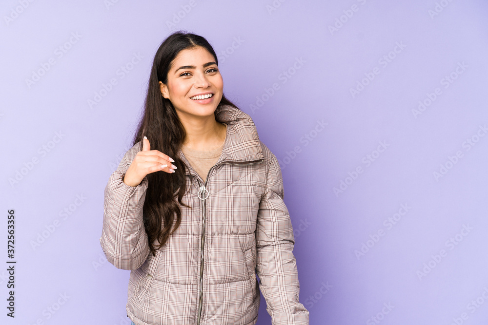 Young indian woman isolated on purple background laughing about something, covering mouth with hands. Young indian woman isolated on purple background laughing about something, covering mouth with hands.