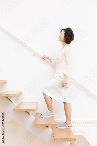 階段を上るシニア女性