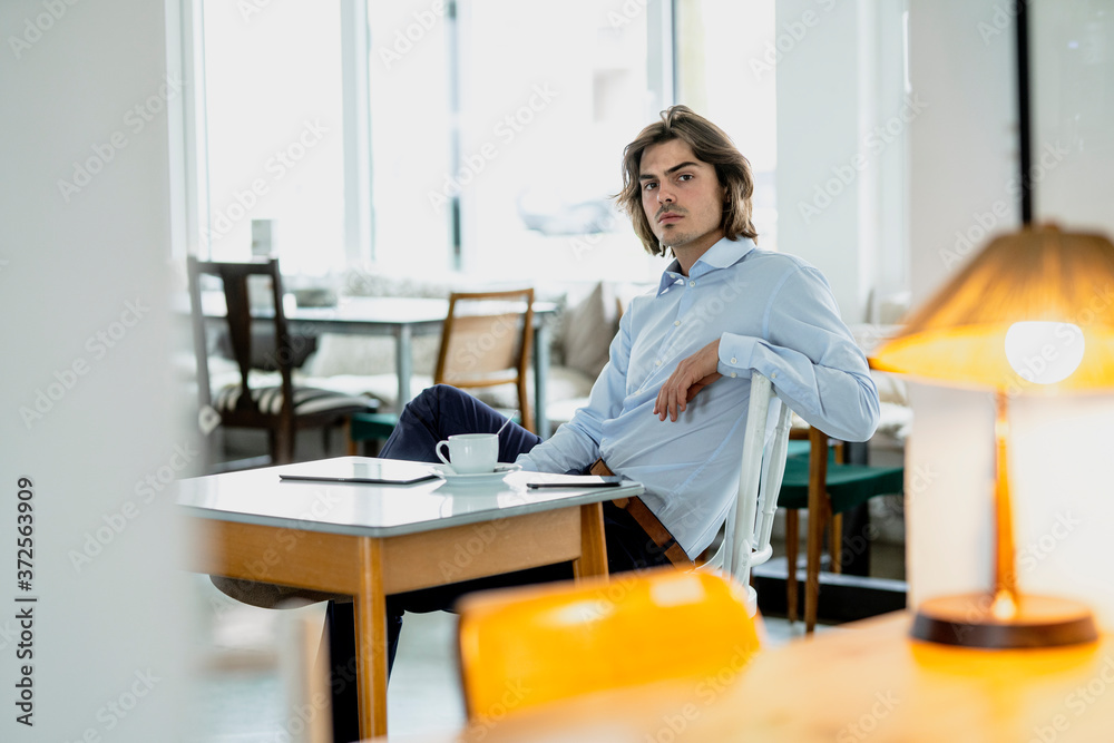 Serious businessman with coffee on table sitting in restaurant Serious businessman with coffee on table sitting in restaurant