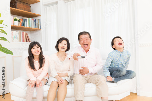 テレビを見る祖父母と孫