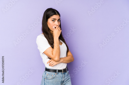 Young indian woman isolated on purple background scared and afraid. © Asier