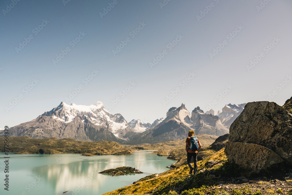 Mature man walking by lake against clear sky at Torres Del Paine National Park, Patagonia, Chile Mature man walking by lake against clear sky at Torres Del Paine National Park, Patagonia, Chile