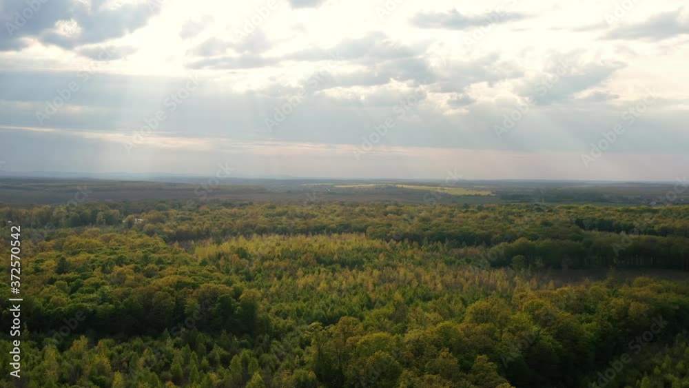 Aerial drone view of natural landscape with beautiful sky. The suns rays illuminate the forest from above Aerial drone view of natural landscape with beautiful sky. The suns rays illuminate the forest from above