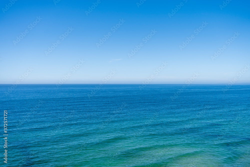 Beautiful blue green ocean seascape view with wave lines. Horizon line at sea and clear blue sky. Travel, vacation, holidays, relax feeling