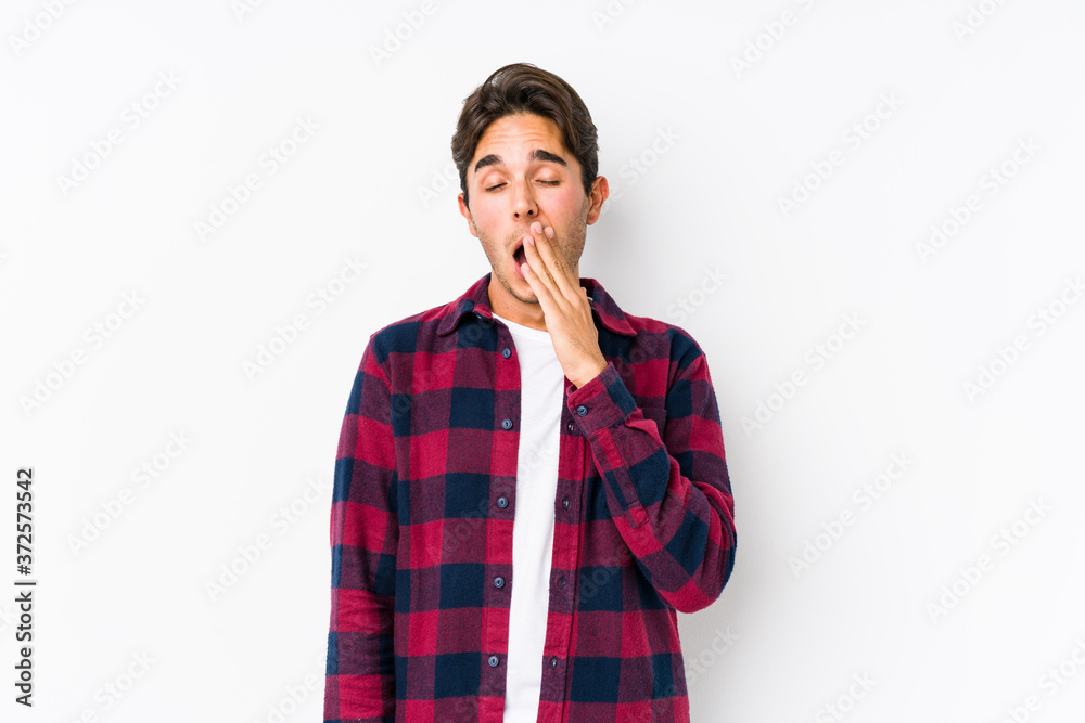 Young caucasian man posing in a pink background isolated yawning showing a tired gesture covering mouth with hand. Young caucasian man posing in a pink background isolated yawning showing a tired gesture covering mouth with hand.