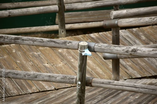 Elevated wooden structure with abandoned mask attached to pole. photo