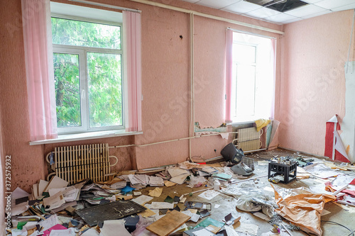 Room of an old abandoned building filled with trash on the floor photo