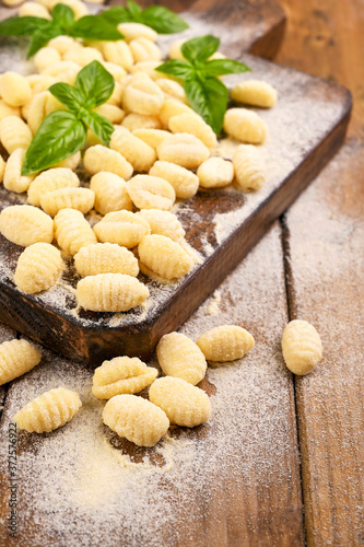Gnocchi with potatoes. Traditional italian food from Rome, Sardinia, south of italy. Homemade gnocchi with parmesan, egg, cornmeal (semolina). On a wooden table. High quality photo. Copy space 