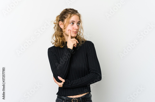 Young caucasian woman on white backrgound contemplating, planning a strategy, thinking about the way of a business.