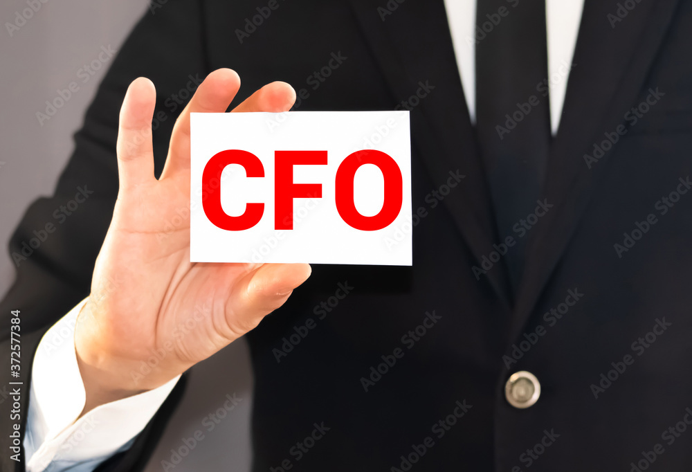 CFO letters or Chief Financial Officer on the card held by a man hand, vintage tone CFO letters or Chief Financial Officer on the card held by a man hand, vintage tone