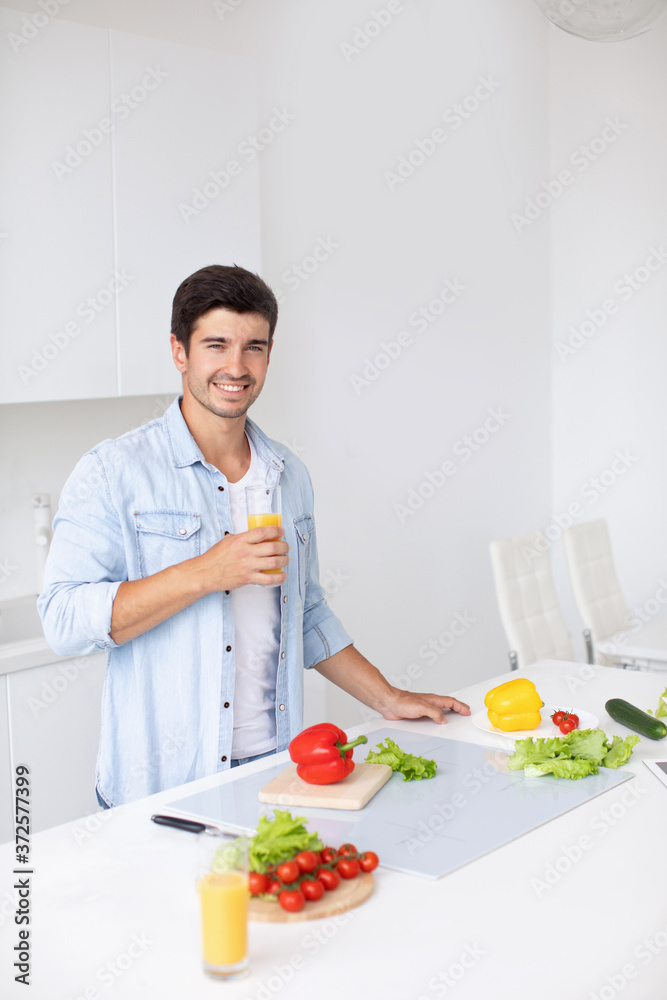 Handsome man standing in the bright kitchen. Handsome man standing in the bright kitchen.