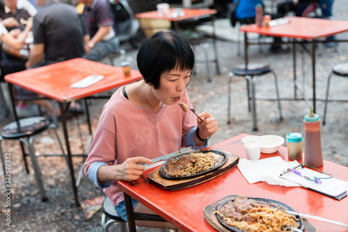 woman eat Taiwanese night market steak