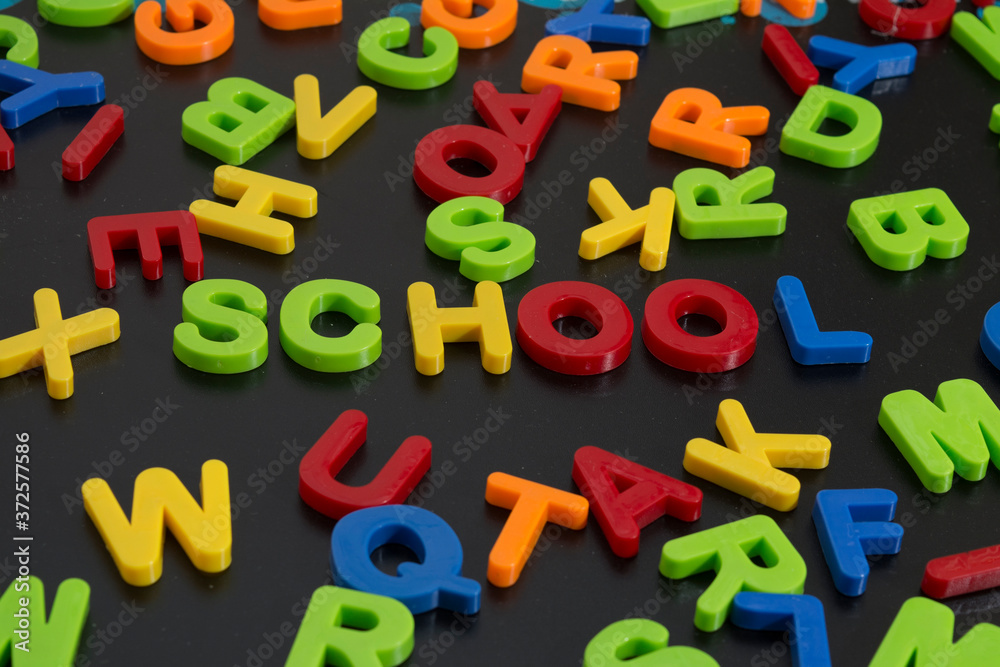 Naklejka premium letras de plastico formando la palabra escuela