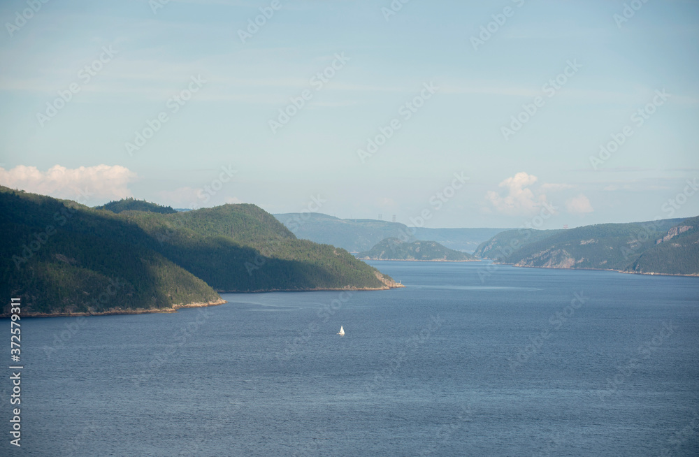 A sailboat is shown on the Saguenay Fjord in the Saguenay region of Quebec Canada