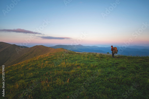 a man walks along a mountain range.  © Taras