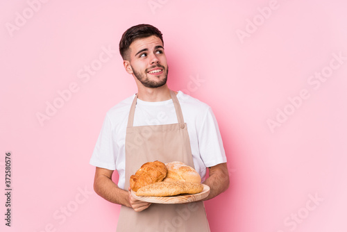 Young caucasian baker man isolated dreaming of achieving goals and purposes