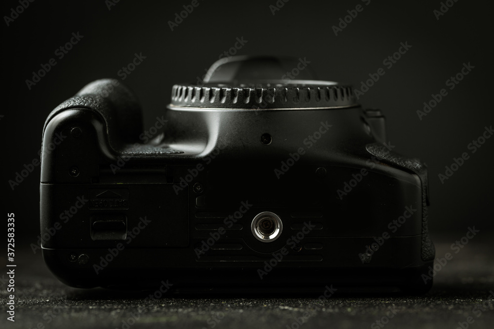 Fototapeta premium Bottom view of photo camera body on the black background. Tripod mount