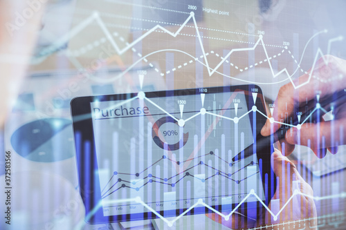 Double exposure of man's hands holding and using a phone and financial chart drawing. Market analysis concept.