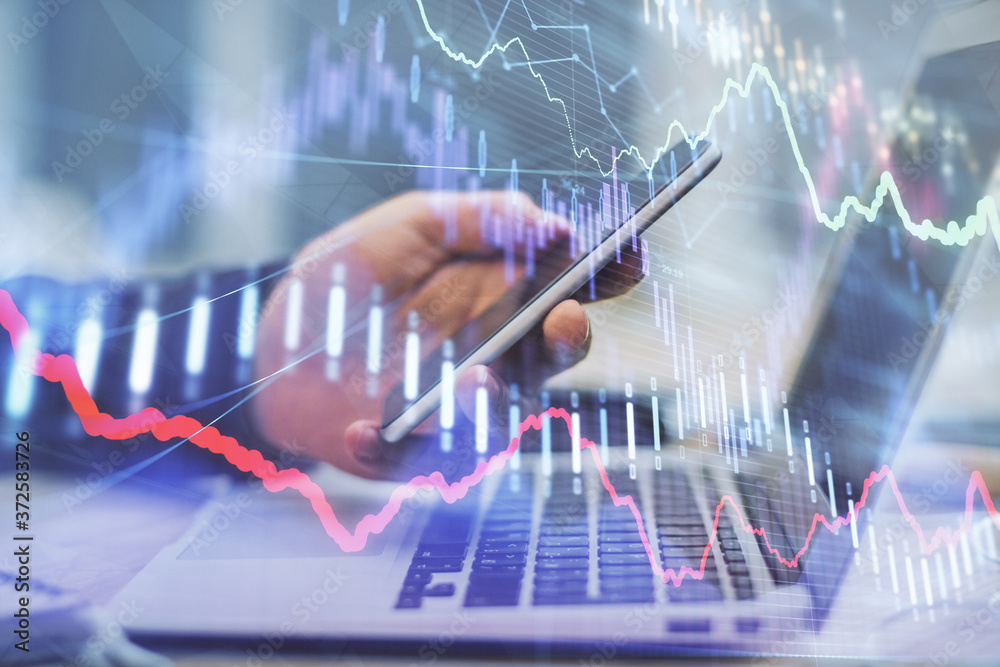 Double exposure of man's hands holding and using a phone and financial graph drawing. Analysis concept. Double exposure of man's hands holding and using a phone and financial graph drawing. Analysis concept.