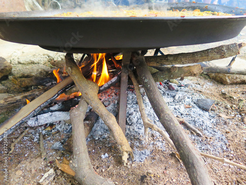 pan of paella on burning wood